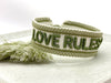 Canvas Statement Armband Love Rules Weiß Grün Quasten besticktes Webarmband